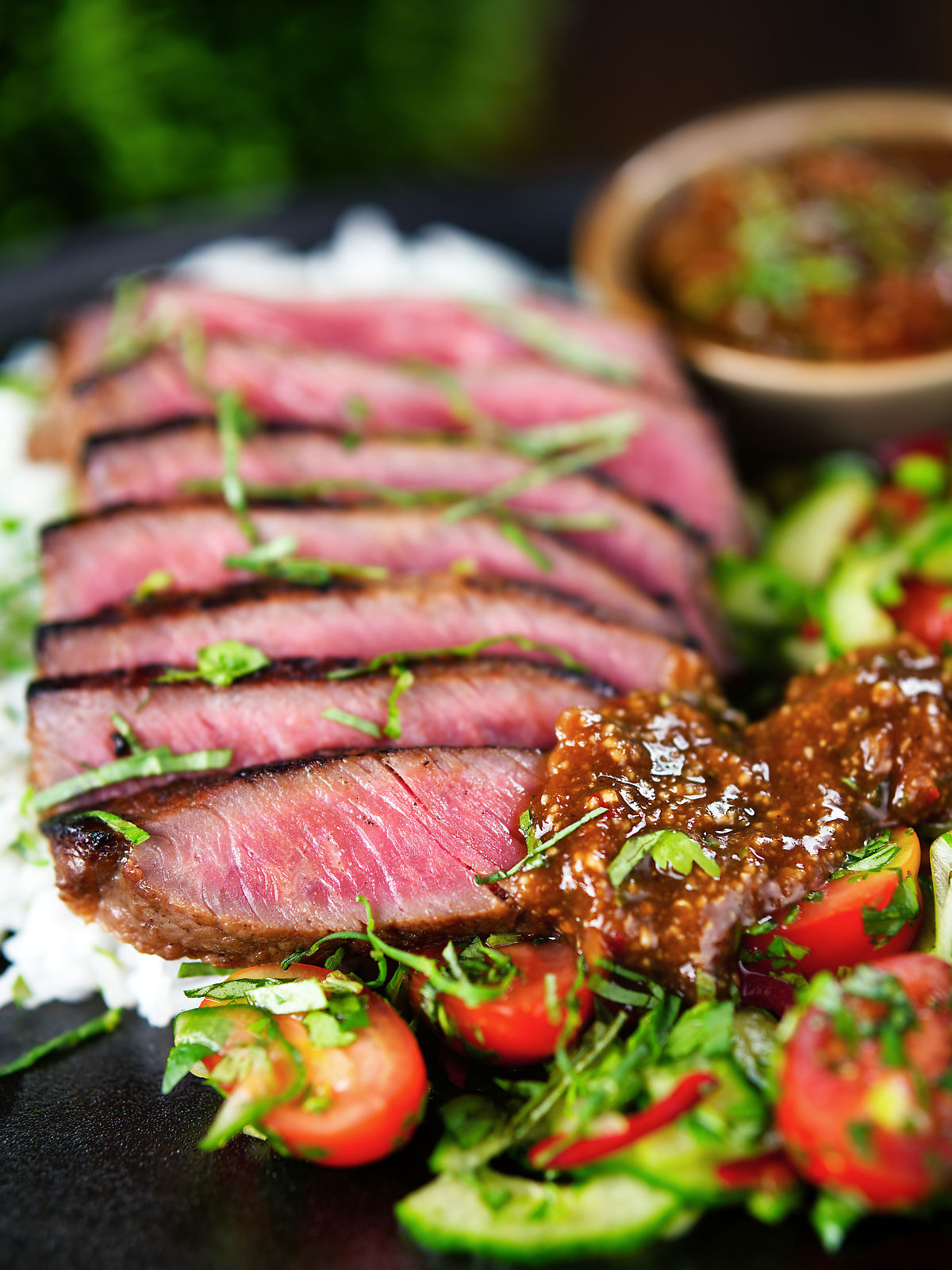 Thai Crying Tiger Steak (Suea Rong Hai) with a spicy dipping sauce, rice, and tomato and cucumber salad.