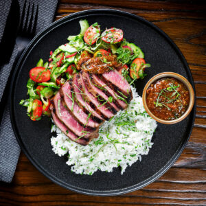 Thai Crying Tiger Steak (Suea Rong Hai) with a spicy dipping sauce, rice and side salad.