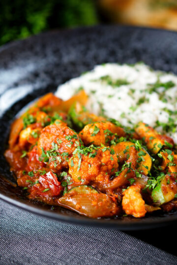 Vegan vegetable rogan josh curry with rice, naan and fresh coriander.