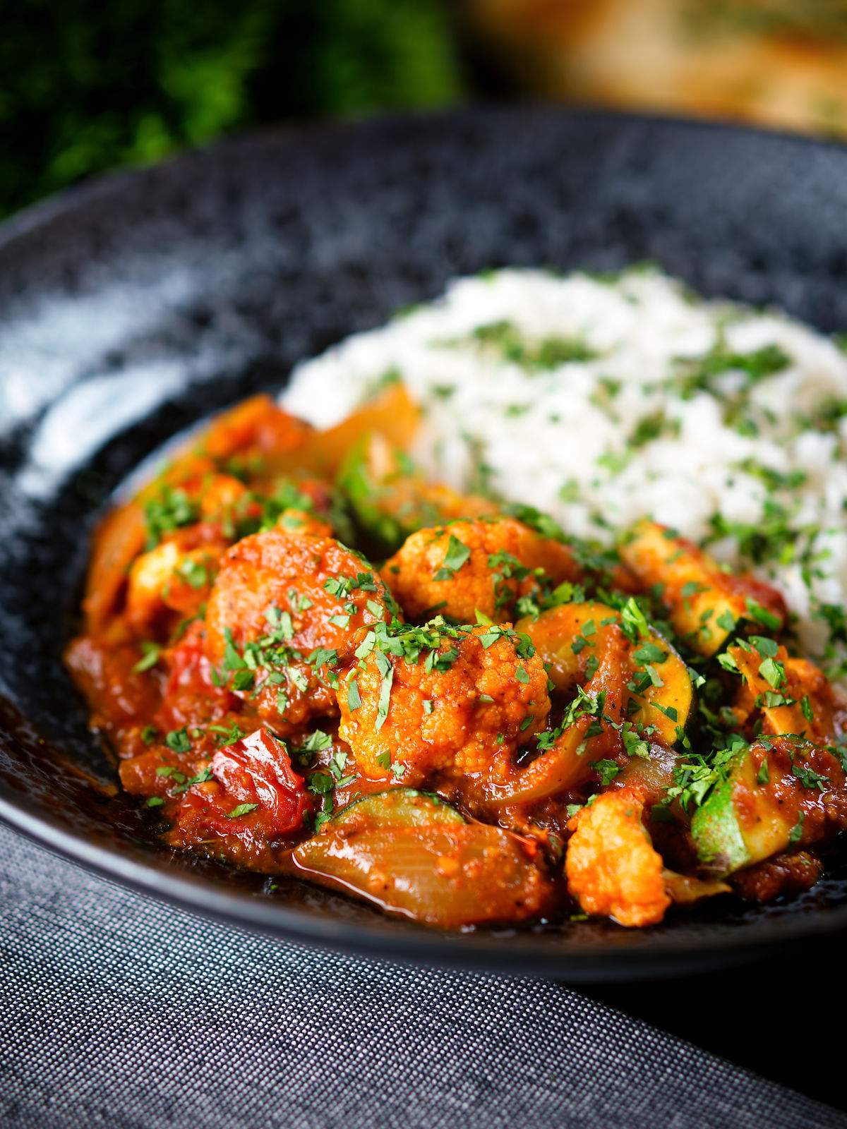 Vegan vegetable rogan josh curry with rice, naan and fresh coriander.