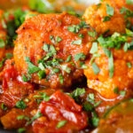 Close-up vegan vegetable rogan josh curry with rice and fresh coriander.