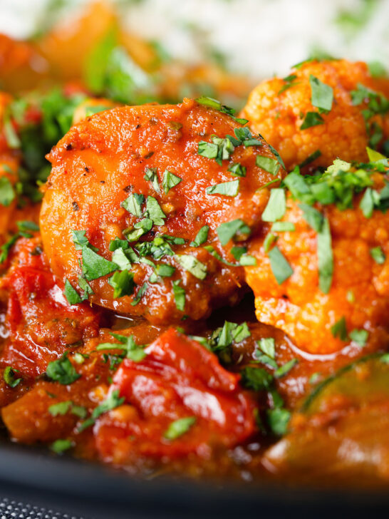 Close-up vegan vegetable rogan josh curry with rice and fresh coriander.