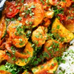 Close-up overhead vegan vegetable rogan josh curry with rice and fresh coriander.