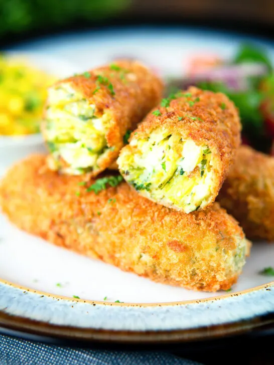Crispy vegetarian Glamorgan sausages cut open to show the filling.