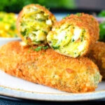 Close-up crispy vegetarian Glamorgan sausages cut open to show the filling.