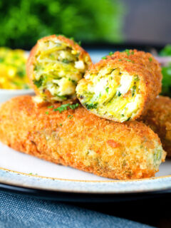 Close-up crispy vegetarian Glamorgan sausages cut open to show the filling.