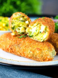Close-up crispy vegetarian Glamorgan sausages cut open to show the filling.