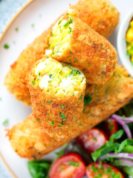 Close-up overhead crispy vegetarian Glamorgan sausages cut open to show the filling.