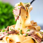 Creamy steak and mushroom pasta with a "Diane" sauce being picked up with a fork.