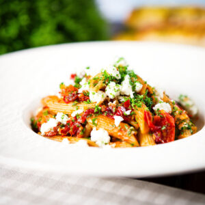Spicy harissa, sun-dried tomato, pepper and feta cheese pasta (penne).