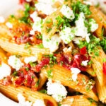 Close-up rose harissa, sun-dried tomato, pepper and feta cheese pasta.