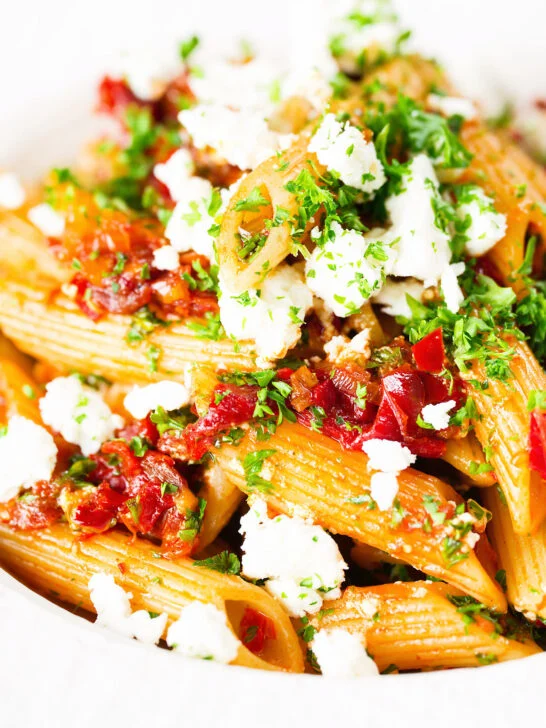 Close-up rose harissa, sun-dried tomato, pepper and feta cheese pasta.