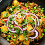 Overhead close-up minced beef, potato and pea curry (aloo keema matar).