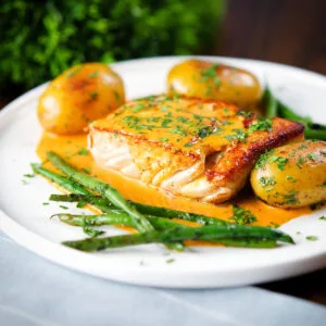 Pan fried halibut fillet with Thai yellow curry sauce, new potatoes and fine beans.