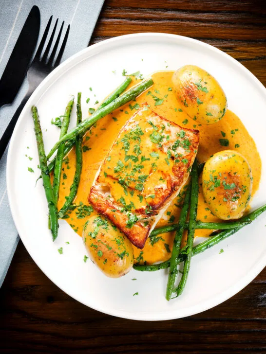 Overhead fried halibut with Thai yellow curry sauce, potatoes, green beans and coriander.