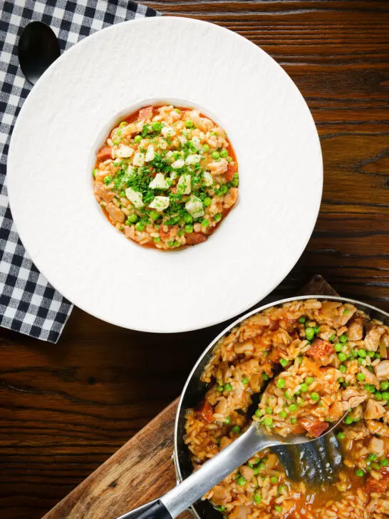 Overhead chicken and chorizo risotto with peas, Manchego cheese and fresh parsley.
