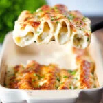 Baked crab meat, fennel and cottage cheese cannelloni with a parmesan crust being served.