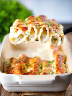 Baked crab meat, fennel and cottage cheese cannelloni with a parmesan crust being served.