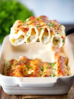 Baked crab meat, fennel and cottage cheese cannelloni with a parmesan crust being served.