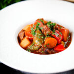 Filipino beef kaldereta (caldereta) stew garnished with coriander.