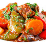 Close-up Filipino beef kaldereta (caldereta) stew garnished with coriander.