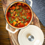 Overhed Filipino beef kaldereta (caldereta) stew garnished with coriander in its cooking pot.