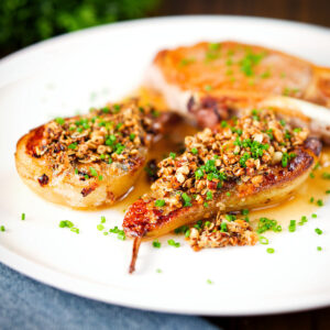 Blue cheese roasted pears with a nutty crumb and cider sauce served with a pork chop.