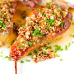 Close-up blue cheese roasted pears with a nutty crumble and cider sauce.