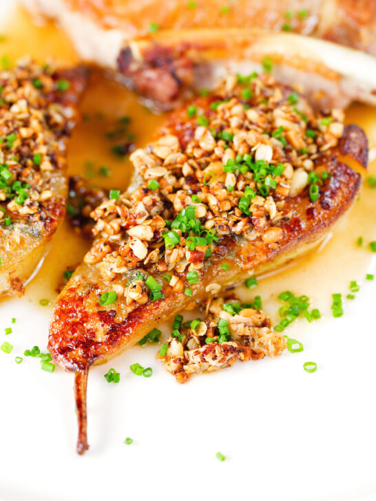 Close-up blue cheese roasted pears with a nutty crumble and cider sauce.