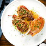 Overhead blue cheese roasted pears with a nutty crumble and cider sauce served with a pork chop.