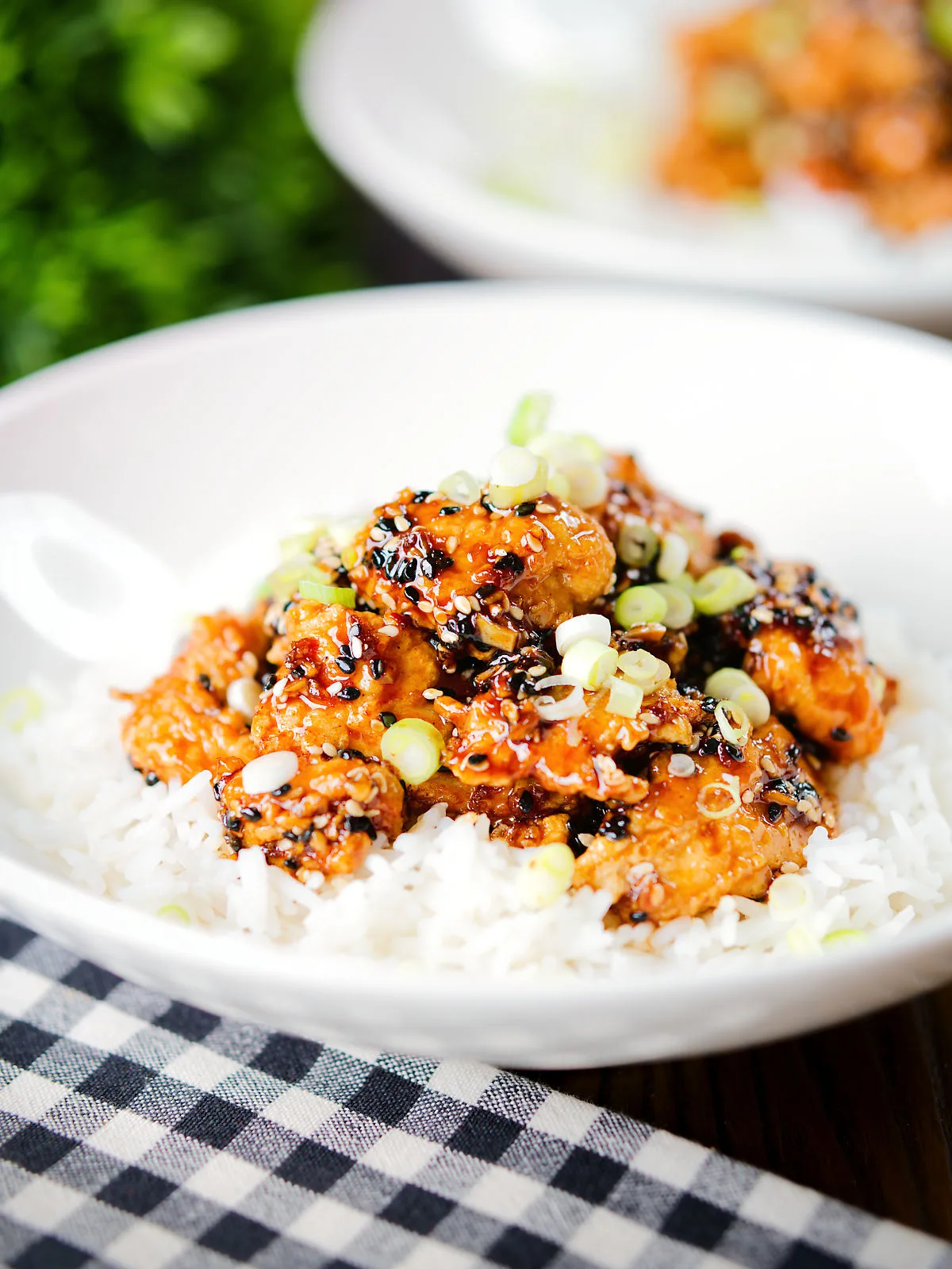 Crispy sticky sesame chicken served with white rice and spring onions.