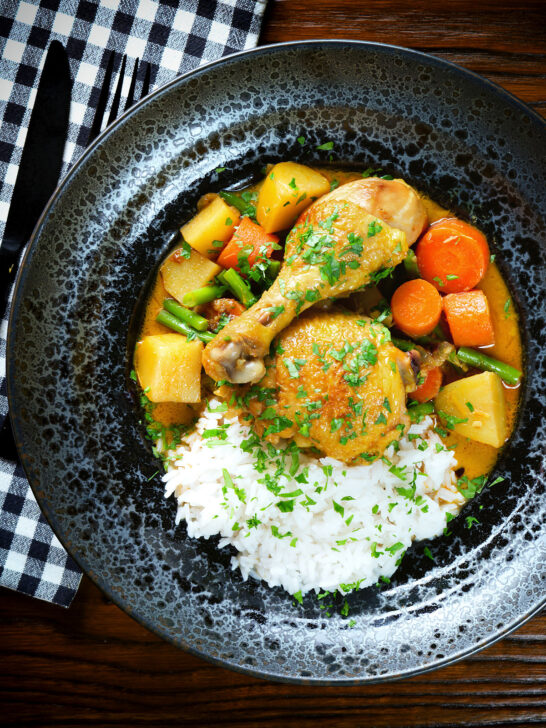Overhead Vietnamese yellow chicken curry (ca ri ga) served with jasmine rice.
