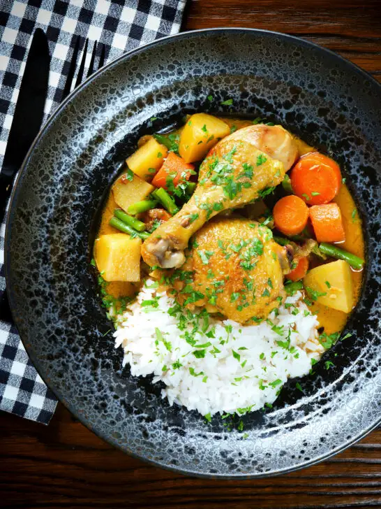 Overhead Vietnamese yellow chicken curry (ca ri ga) served with jasmine rice.
