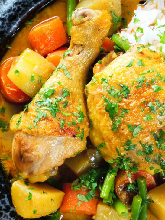 Close-up overhead Vietnamese yellow chicken curry (ca ri ga) served with jasmine rice.