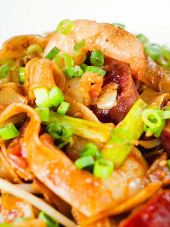Close-up char kway teow (flat rice noodle stir fry) with Chinese sausage and prawns.