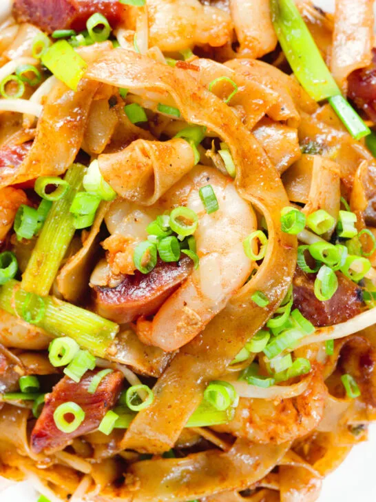 Close-up overhead char kway teow (flat rice noodle stir fry) with Chinese sausage and prawns.