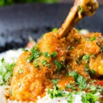 Close-up Pakistani chicken salan curry with plain rice.