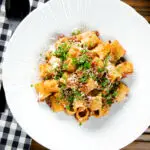 Overhead pork mince pasta ragu with balsamic vinegar, sun-dried tomatoes and sage.