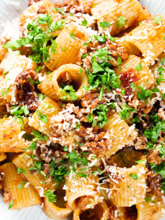 Overhead close-up pork mince pasta ragu with balsamic vinegar, sun-dried tomatoes and sage.