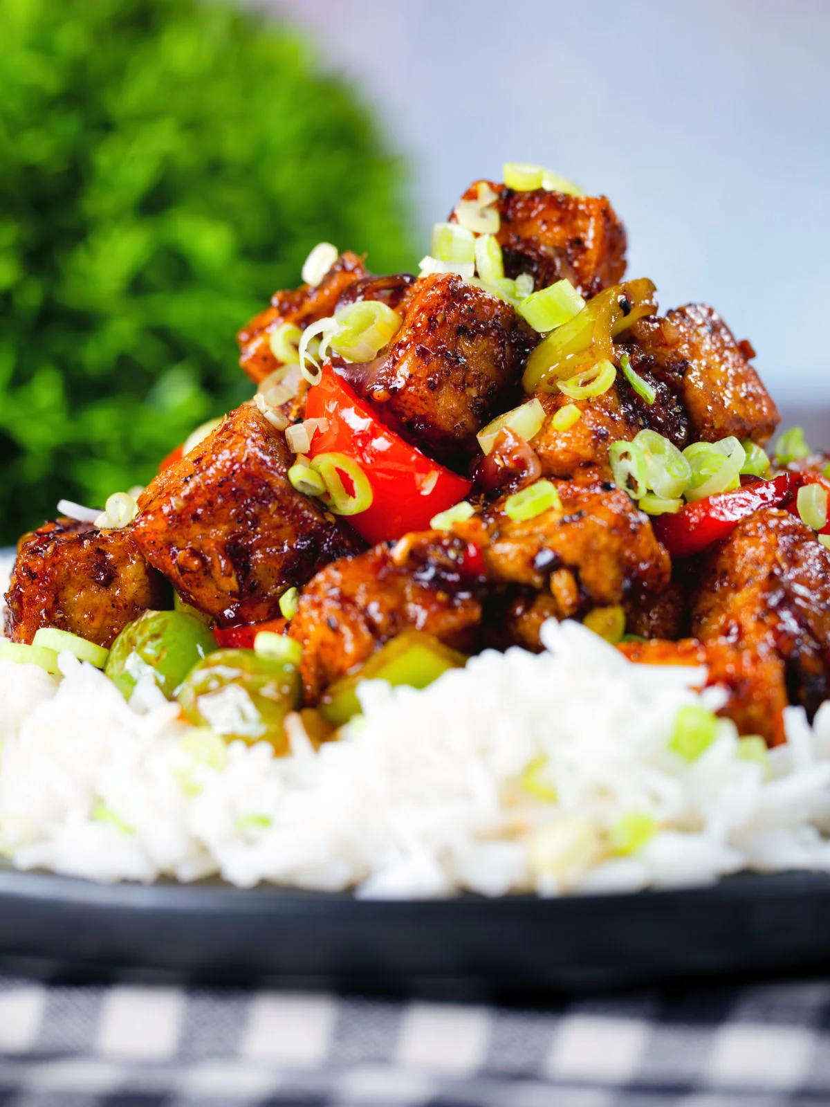 Close-up vegan/vegetarian Szechuan tofu with peppers and red onion served with white rice.