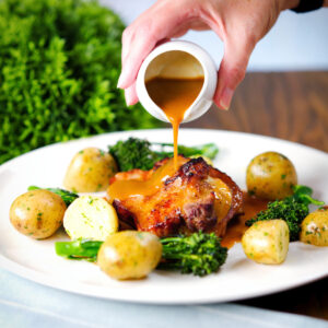 Baked sage, apple and bacon stuffed pork shoulder chops, with cider gravy, buttered potatoes and broccoli.