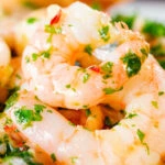 Close-up Camarao à guilho (Portuguese garlic prawns) served with toasted bread.