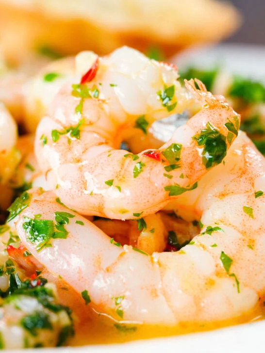 Close-up Camarao à guilho (Portuguese garlic prawns) served with toasted bread.