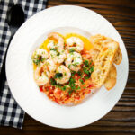 Camarao à guilho (Portuguese garlic prawns) served with tomato rice and toasted bread.