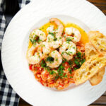 Overhead camarao à guilho (Portuguese garlic prawns) served with arroz con tomate and toasted bread.