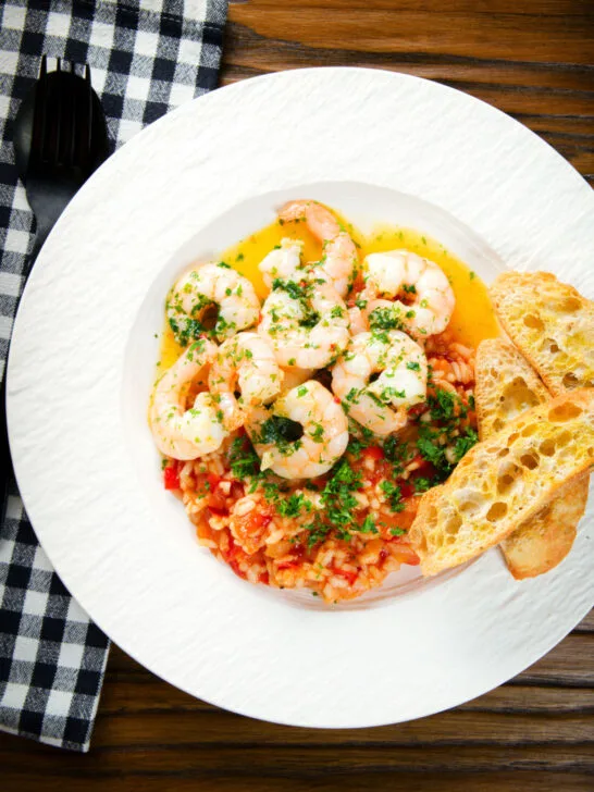 Overhead camarao à guilho (Portuguese garlic prawns) served with arroz con tomate and toasted bread.