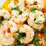 Close-up overhead Camarao à guilho (Portuguese garlic prawns) served with arroz con tomate.