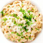 Overhead close-up creamy Philadelphia or cream cheese pasta with garlic and chives.
