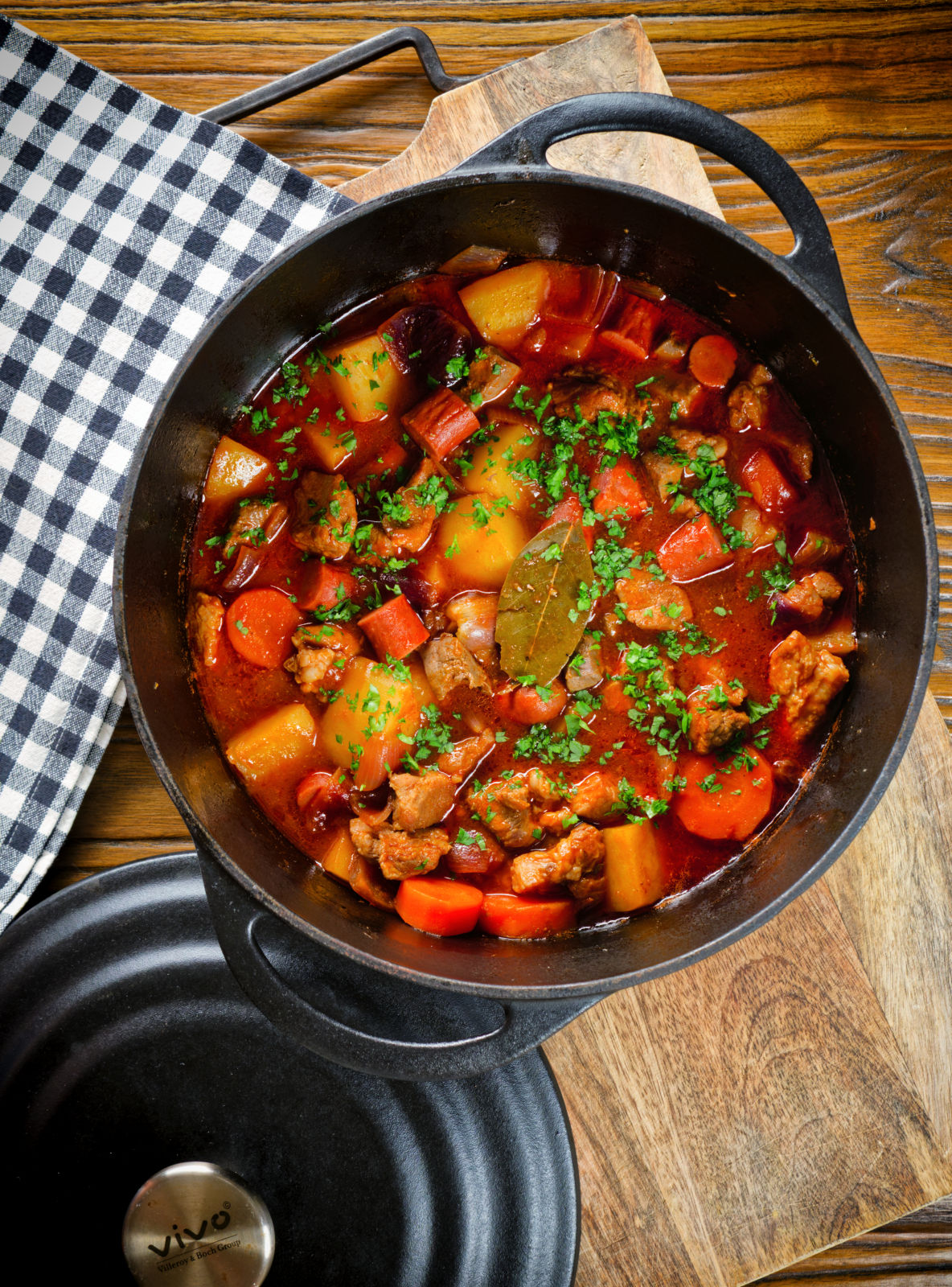 Overhead Filipino pork menudo with liver, hotdog sausages, potatoes and carrots in its cooking pot.