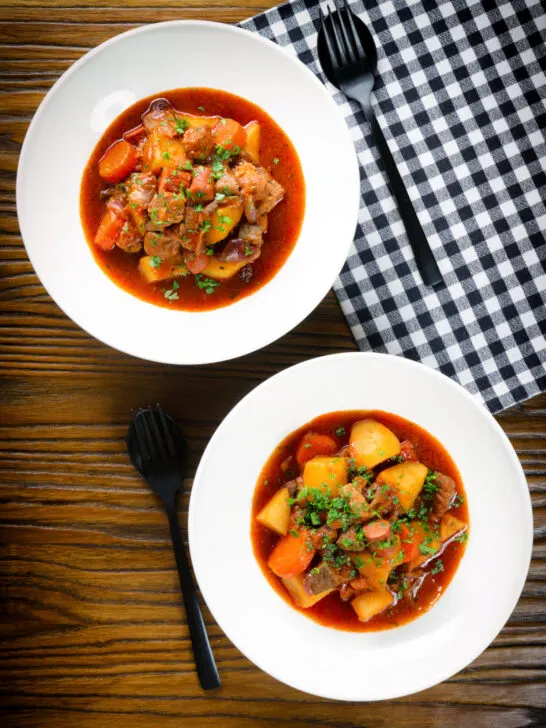 Overhead Filipino pork menudo with liver, hotdog sausages, potatoes and carrots.